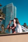 Girl putting on sunglasses in city with palm trees — Stock Photo
