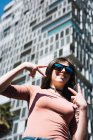 Portrait d'une adolescente montrant des signes de victoire dans la rue en ville — Photo de stock
