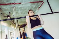 Donna forte che fa pull up in palestra — Foto stock