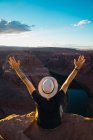 Vista posteriore dell'uomo che tende le braccia e ammira la vista del canyon contro il cielo mentre viaggia attraverso la costa occidentale degli Stati Uniti — Foto stock