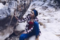 Dall'alto donna sorridente attraente che riposa su roccia su montagna — Foto stock