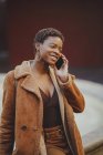African American elegant woman talking on mobile phone on street — Stock Photo