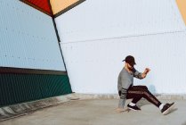 Guy performing dancing near wall of modern building on city street — Stock Photo