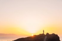 Роки побережье с дорогой и маяком у моря вечером в Тенерифе, Канарские острова, Испания — стоковое фото