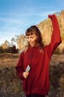 Junge Hipster-Frau mit erhobener Hand hört Musik mit Handy und tanzt auf dem Land — Stockfoto