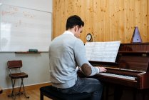 Vue arrière d'un bel homme jouant du piano pendant la répétition en studio d'enregistrement
. — Photo de stock
