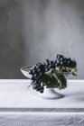 Bunch of fresh grapes on vintage plate on table — Stock Photo