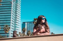 Menina adolescente olhando para seu smartphone na rua em um dia ensolarado — Fotografia de Stock