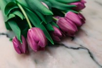 Buquê de tulipas rosa frescas na superfície de mármore — Fotografia de Stock