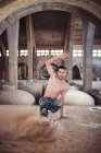 Jeune homme dansant sur le sable dans un vieux bâtiment minable — Photo de stock