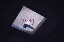 Joven bailarina saltando sobre el agujero en el techo, vista de ángulo bajo - foto de stock