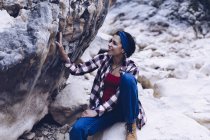 Von oben attraktive lächelnde Frau, die auf einem Felsen auf dem Berg ruht — Stockfoto