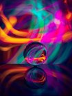 Кришталева куля на поверхні з відображенням біля абстрактного світить — стокове фото