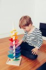 Blonde cute boy playing with waldorf sounding tower with marbles — Stock Photo