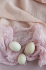 Свіжі білі яйця на рожевій тканині — стокове фото