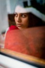 Side view through window of lovely pensive brunette lady looking away — Stock Photo