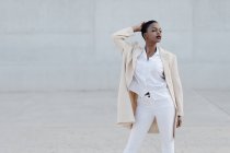 Moda modello a pelo corto in abito bianco in posa contro muro grigio — Foto stock