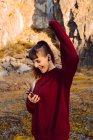 Jeune femme hipster avec une main surélevée écoutant de la musique avec téléphone portable et dansant à la campagne — Photo de stock