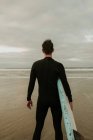 Person mit Surfbrett in der Nähe des Meeres — Stockfoto