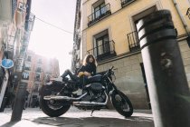 Mujer joven en moto personalizada - foto de stock