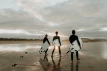 Persone con tavola da surf a piedi vicino al mare — Foto stock