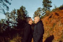 Гомосексуальна пара стоїть обличчям до обличчя на шляху в лісі в сонячний день — стокове фото