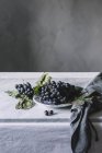 Bunch of fresh grapes on plate on table — Stock Photo