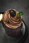 Köstliche hausgemachte Schokolade Cupcake auf schwarzem Teller — Stockfoto