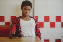 Афроамериканець жінка, сидячи за столом у кафе — стокове фото