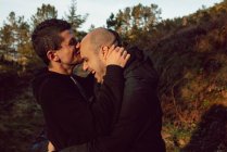 Felice coppia omosessuale che abbraccia nella foresta nella giornata di sole — Foto stock