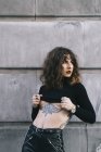 Jeune femme tatouée posant sensuelle dans la rue — Photo de stock