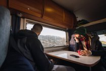 Guys sitting in mobile house and looking through window at picturesque mountain Teide in Tenerife, Canary Islands, Spain — Stock Photo