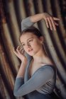 Sensual jovem mulher olhando para longe e gesticulando com as mãos enquanto dança balé em tubo enferrujado — Fotografia de Stock