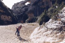 Giovane coppia che gioca nel canyon tra le montagne rocciose nella giornata di sole — Foto stock