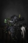 Куча винограда на металлической винтажной пластине на темном фоне — стоковое фото