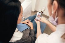 Dentiste démontrant smartphone avec balayage des dents à la femme en clinique — Photo de stock
