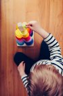 Блондинка милий хлопчик грає з вальдорфською звуковою вежею з кульками — стокове фото