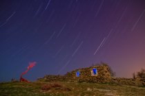 Lange Belichtung des erstaunlichen Himmels mit Sternen am Abend und gealterte Felskonstruktion auf dem Hügel — Stockfoto