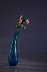Flores rosa em vaso de vidro elegante no fundo cinza escuro — Fotografia de Stock
