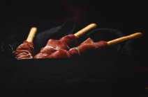 Gressinis con jamón serrano típico español sobre fondo oscuro - foto de stock