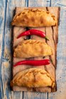 Tortini fatti in casa e peperoncini rossi freschi su tavola di legno — Foto stock