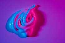 Pfütze aus heller Neon-Acrylfarbe auf leuchtend violettem Hintergrund — Stockfoto
