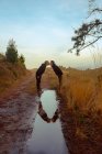 Água slop com reflexo de casal homossexual abraçando e beijando na estrada — Fotografia de Stock