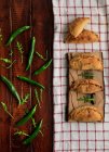 Домашние выпеченные котлеты и зеленый перец чили с листьями рукколы на деревянном столе — стоковое фото
