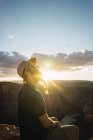 Вид сбоку на бородатого парня с рюкзаком, смотрящего на красивый каньон и спокойную реку в солнечный день на западном побережье США — стоковое фото