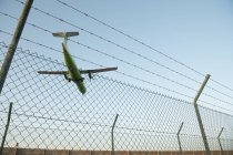 Avião atrás da cerca de segurança — Fotografia de Stock