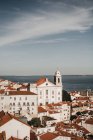 Amazing drone view of blue sky over tiled roofs of old houses and calm sea in Lisbon, Portugal — Fotografia de Stock
