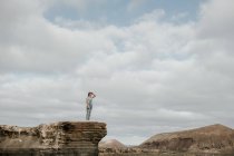Анонимная женщина стоящая на каменистой местности — стоковое фото