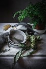 Different herbs in bowls placed on rustic table — Stock Photo