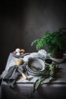 Uova e diverse erbe in ciotole poste su tavola rustica — Foto stock